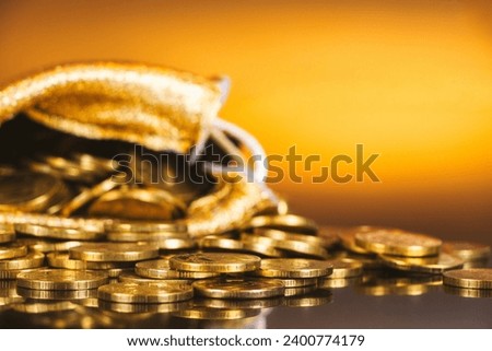 Gold coins in sack. Gold money on orange background. Copy space. A pile of coins. A bag with gold coins. Treasure hunt Royalty-Free Stock Photo #2400774179