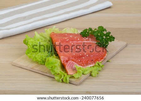 Salmon  with salad leaves and parsley on wooden background