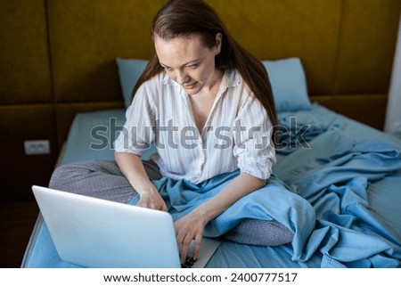 Young woman using a laptop in bed