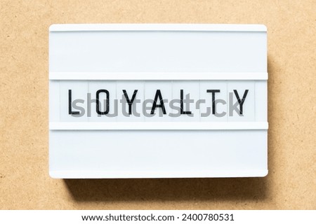 Lightbox with word loyalty on wood background