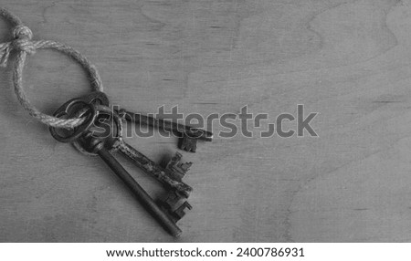 Antique keys on a rough rope lie on a wooden surface