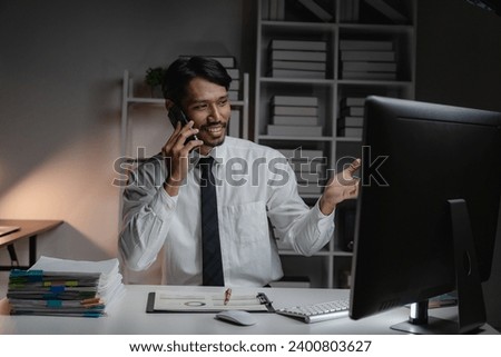 Black businessman planning paperwork and financial reports at desktop computer, young entrepreneur working in strategy, expert in dark office