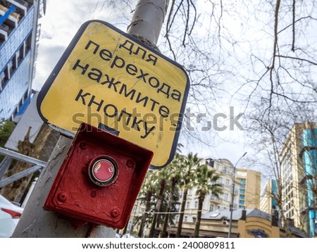 Button for crossing the street at a traffic light. Translation of the inscription: "To go, press the button"