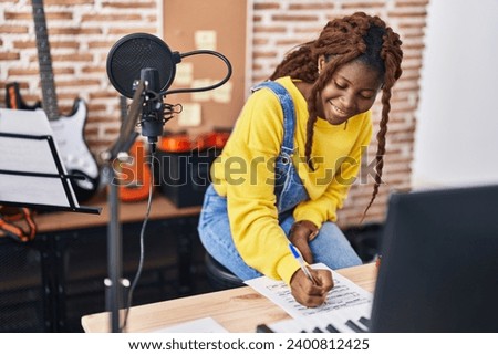 African american woman musician composing song at music studio Royalty-Free Stock Photo #2400812425