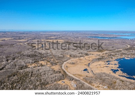 Expansive aerial views over Tay Township, Simcoe County, Ontario, capture the grandeur of the Canadian landscape. From the shimmering waters reflecting the sun's glare to the sprawling patches