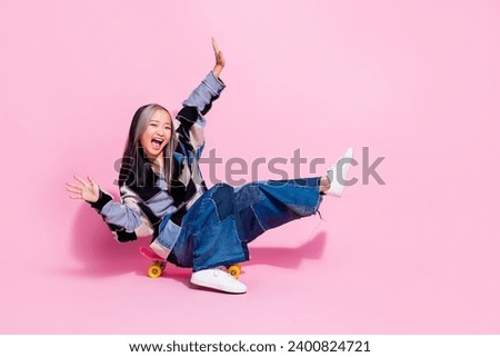 Full length photo of funny careless youngster wear oversize sweatshirt falling from skateboard scream isolated on pink color background
