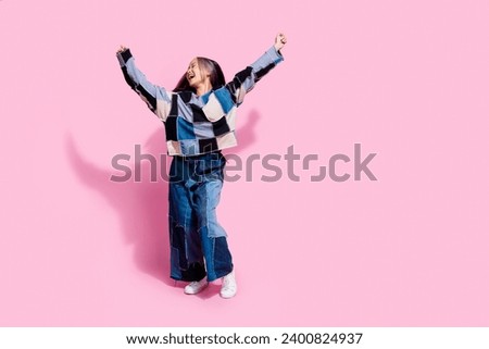 Full length photo of satisfied youngster wear oversize sweatshirt jeans raising fists up win betting isolated on pink color background