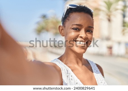 African american woman smiling confident making selfie by camera at seaside