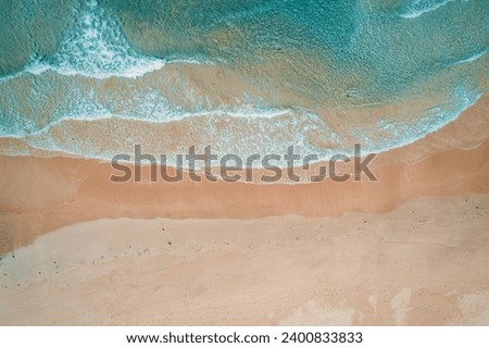 Aerial top view of turquoise ocean wave reaching the coastline. Royalty-Free Stock Photo #2400833833