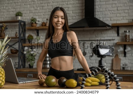 Smiling asian woman working on food blogger concept with fruits and vegetables in kitchen. Vlogging about healthy lifestyle, living on fruits and vegetables