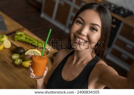 Sport female drinking smoothie and taking selfie in kitchen for vlogging blogging, talking about weight loss, detoxication, antioxidants and minerals, dieting for calories burn