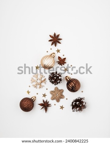 Silhouette of a Christmas tree made of balls, snowflakes, cones, star anise and confetti on a white background. An idea for the new year.