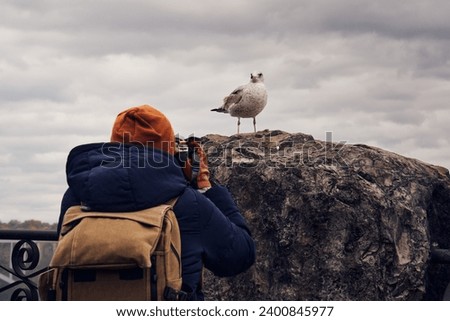 A tourist shooting a photo to a seagull in Niagara Falls