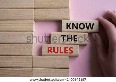 Know the rules symbol. Wooden blocks with words Know the rules. Beautiful pink background. Businessman hand. Business and Know the rules concept. Copy space.