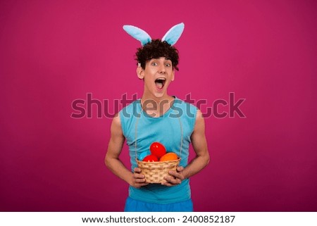 Easter holiday. Funny curly guy in a bunny suit. Pink background.