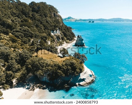 Drone photo above Cathedral Cove in New Zealand showing beaches, different rock formations and fauna.