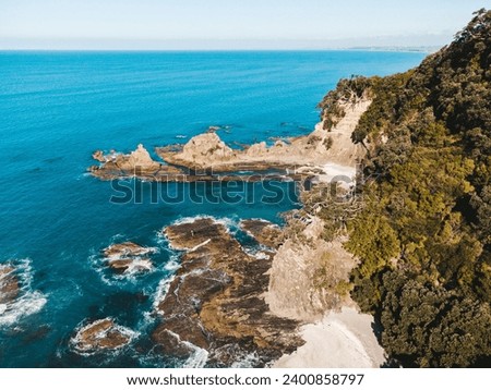 Drone photo above ohope beach in New Zealand showing beaches, different rock formations, flora and fauna.
