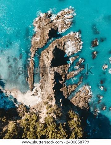 Vertical drone photo above ohope beach in New Zealand showing beaches, different rock formations, flora and fauna. Royalty-Free Stock Photo #2400858799