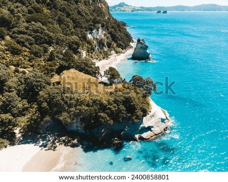 Drone photo above Cathedral Cove in New Zealand showing beaches, different rock formations and fauna.