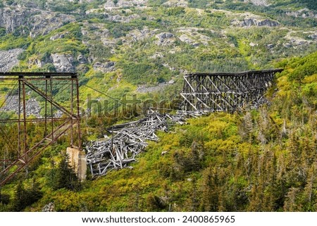 Collapsed trestles railroad bridge in the White Pass and Yukon Route gorge between Skagway, Alaska and the Canadian border Royalty-Free Stock Photo #2400865965