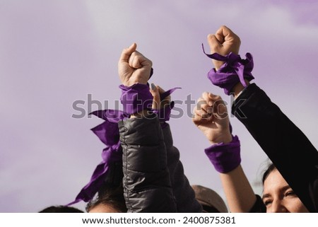 women empowerment : strong women defending rights on 8 march demonstration. Purple colours Royalty-Free Stock Photo #2400875381