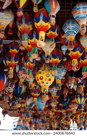 Different colorful souvenirs of air balloons hanging in street market. Handmade decoration and reminders for travellers in Turkey. Symbolic meaning of Cappadocia.