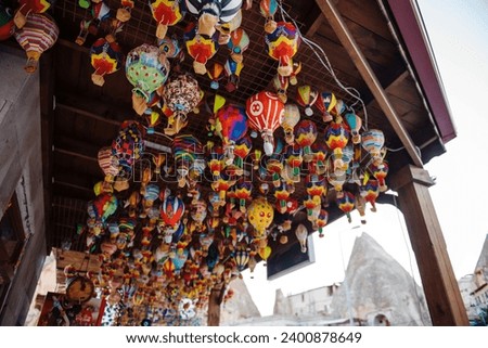Different colorful souvenirs of air balloons hanging in street market. Handmade decoration and reminders for travellers in Turkey. Symbolic meaning of Cappadocia.