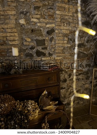 Room with an ancient brick wall in a historic Italian house with chirstmas lights Royalty-Free Stock Photo #2400904827