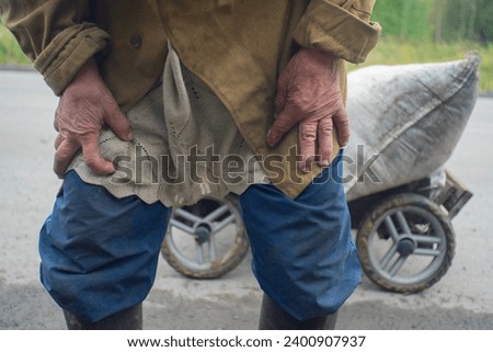 Emaciated hands of a peasant woman and her cart. Royalty-Free Stock Photo #2400907937