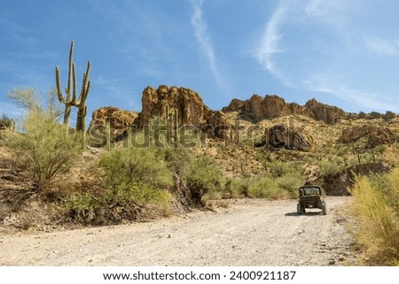 UTV on a trail next to rugged hills and cacti near Box Canyon in Arizona, USA Royalty-Free Stock Photo #2400921187