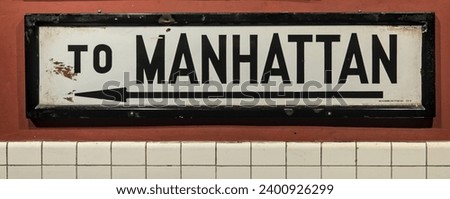 to manhattan subway sign with arrow (old fashioned, antique, vintage, historic) train station signage, nyc, commute, transportation