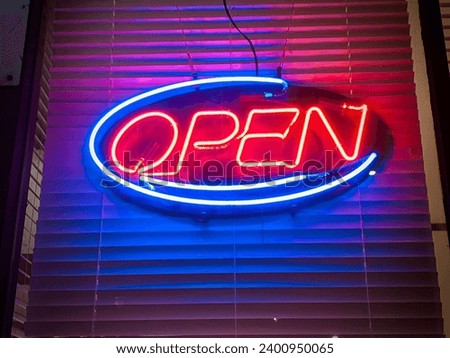 Neon open signage on a restaurant store front window at night with blinds behind. Located on Rideau Street Ottawa Ontario Canada