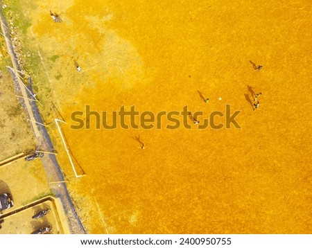 Sports Photography. Aerial Landscapes. Drone view of Children are playing football in the morning. Aerial Shot from a flying drone.
