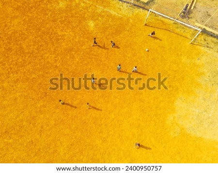 Sports Photography. Aerial Landscapes. Drone view of Children are playing football in the morning. Aerial Shot from a flying drone.