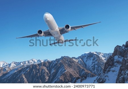 Front view of the passenger airplane flies climb taking off over the pass background of high picturesque mountains. Royalty-Free Stock Photo #2400973771