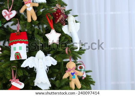 Christmas handmade decorations on Christmas tree on light background