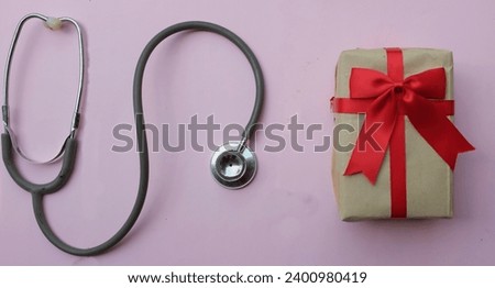 medical stethoscope with gift box isolated on a pink pastel background. concept christmas and new year.horizontal photo
