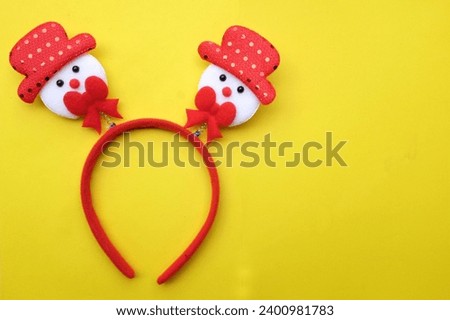 cute Christmas headbands with snowman's isolate on a yellow backdrop. concept of joyful Christmas party,New year is coming soon, festive season decoration with Christmas elements