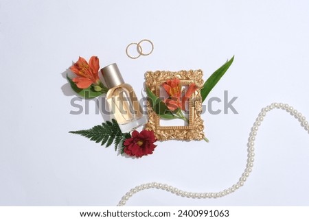 Advertising scene for perfume product with minimal concept. A glass spray bottle decorated with red flowers, green leaves and pearl necklace on a white background
