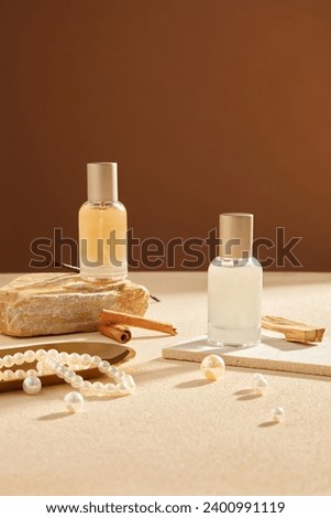 Front view of glass spray bottle unlabeled decorated on brown background with pearl necklace, cinnamon sticks and vanilla. Mockup scene for advertising perfume product