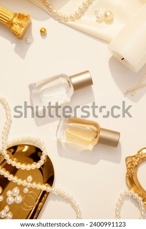 Luxury concept for advertising aromatic oils, perfume products. Model of two glass bottles containing perfume decorated on white background with luxury pearl jewelry, candle and silk fabric