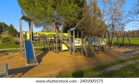 Wooden steel playground children play area with slide bridge and cabin swingset Royalty-Free Stock Photo #2401005575