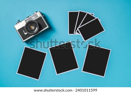Vintage photo camera and empty photo frames on blue background. Travel moment concept