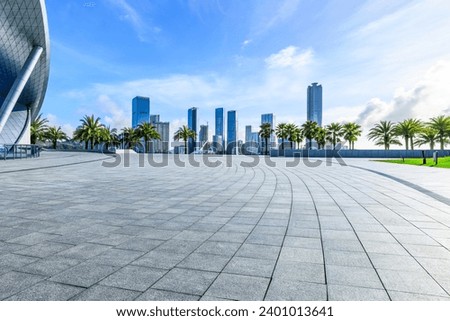 Empty square floors and city skyline with modern buildings under blue sky