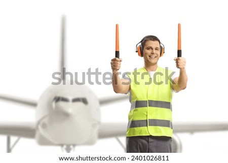Aircraft marshaller signaling with wands in front of an aircraft  Royalty-Free Stock Photo #2401026811