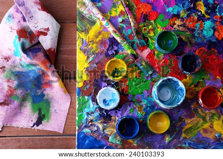 Abstract painting on canvas with cans, brush and rag on wooden table background