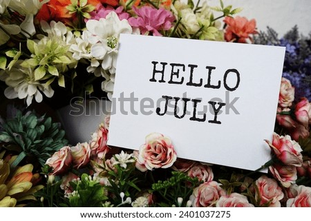 Hello July text message on paper card with beautiful flowers decoration