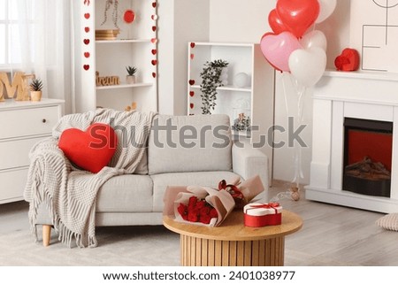 Interior of festive living room with grey sofa, fireplace and decorations for Valentine's Day celebration Royalty-Free Stock Photo #2401038977