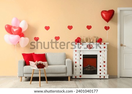 Interior of festive living room with grey sofa, fireplace and decorations for Valentine's Day celebration