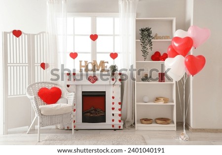 Interior of festive living room with armchair, fireplace and decorations for Valentine's Day celebration